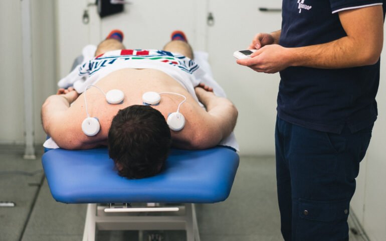 Equipo de fisioterapia en uso con paciente y profesional en clínica